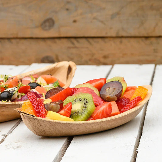 Bandeja Canoa Oval de Folha de Palmeira com frutas variadas como morangos, kiwis e melancias.