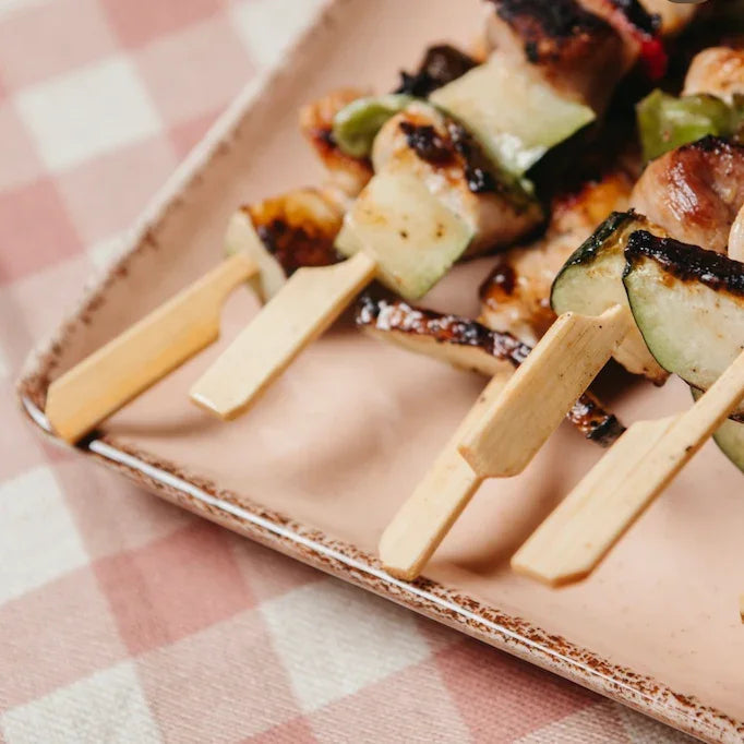 Espeto Bambu Golf 12cm com carnes e vegetais grelhados em prato, ideal para servir em restaurantes e fast food.