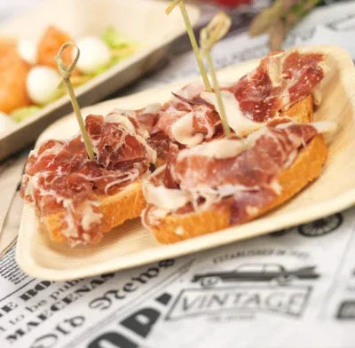 Prato Quadrado de Folha de Palmeira com tapas de presunto em serviço de catering
