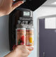 Instalação do ambientador profissional Rubbermaid Microburst Duet em suporte, mostrando recargas de fragrância.