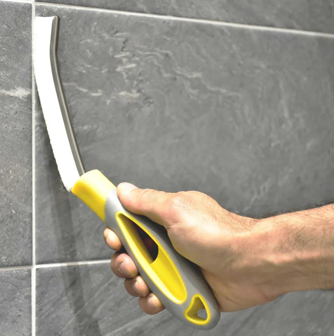 Escova de Juntas Ergonómica Extra Forte em uso na limpeza de azulezos de uma casa de banho