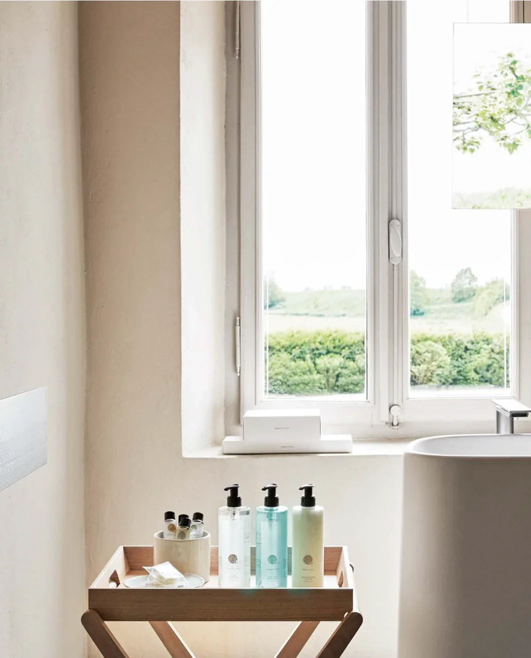 Gel de Banho Geneva Guild 5L exposto em ambiente de banheiro com janela iluminada ao fundo.