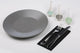Guardanapos de Mesa Pretos Dobrados 1-8 PPP 40x40cm com prato cinza e talheres em uma mesa organizada.
