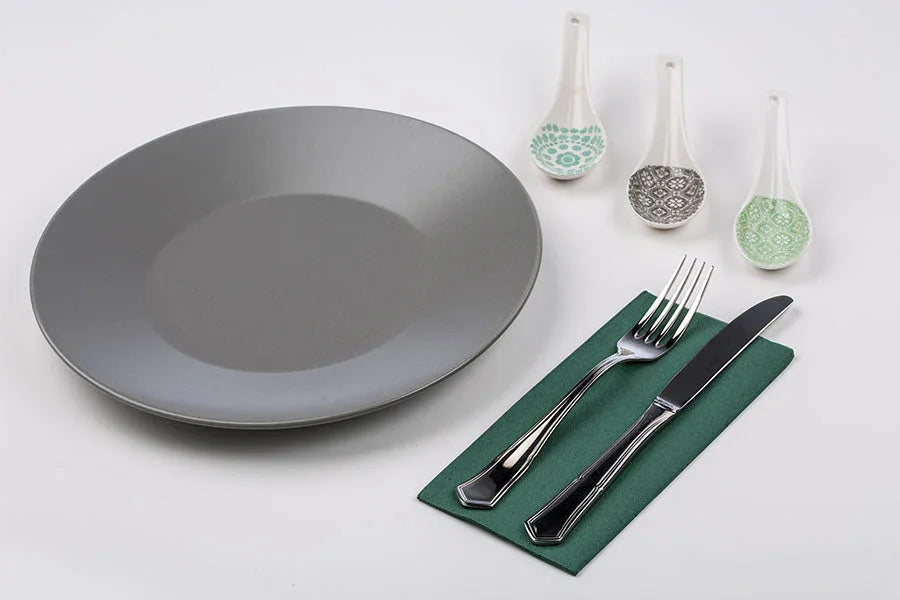 Guardanapos de Mesa Verdes Dobrados 1-8 PPP 40x40cm sobre prato cinza com talheres.