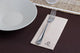 Guardanapos de Mesa Eco Nature Dobrados 1-8 PPP 40x40cm ao lado de um prato e garfo em mesa decorada