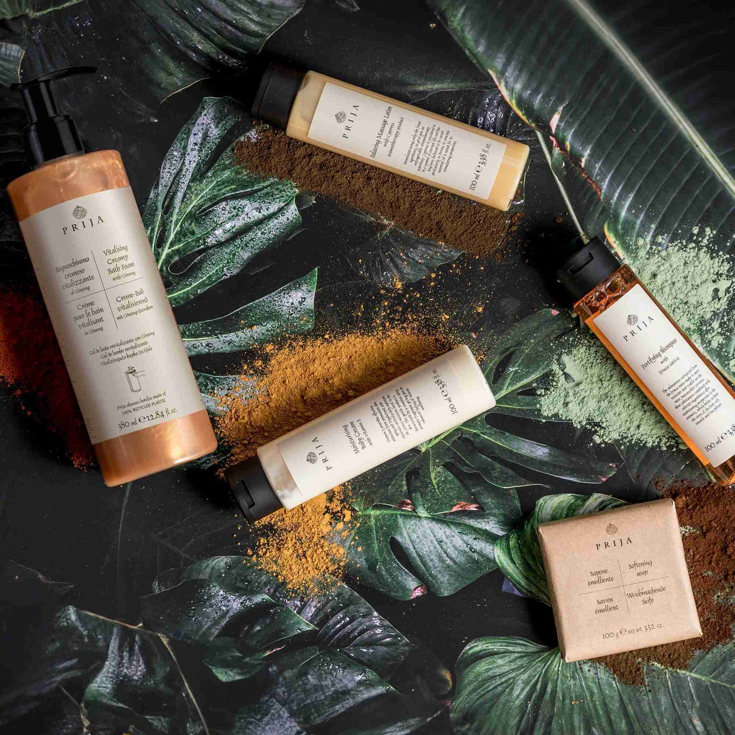 Gel de Banho e Champô 2em1 PRIJA e outros produtos naturais sobre folhas verdes.